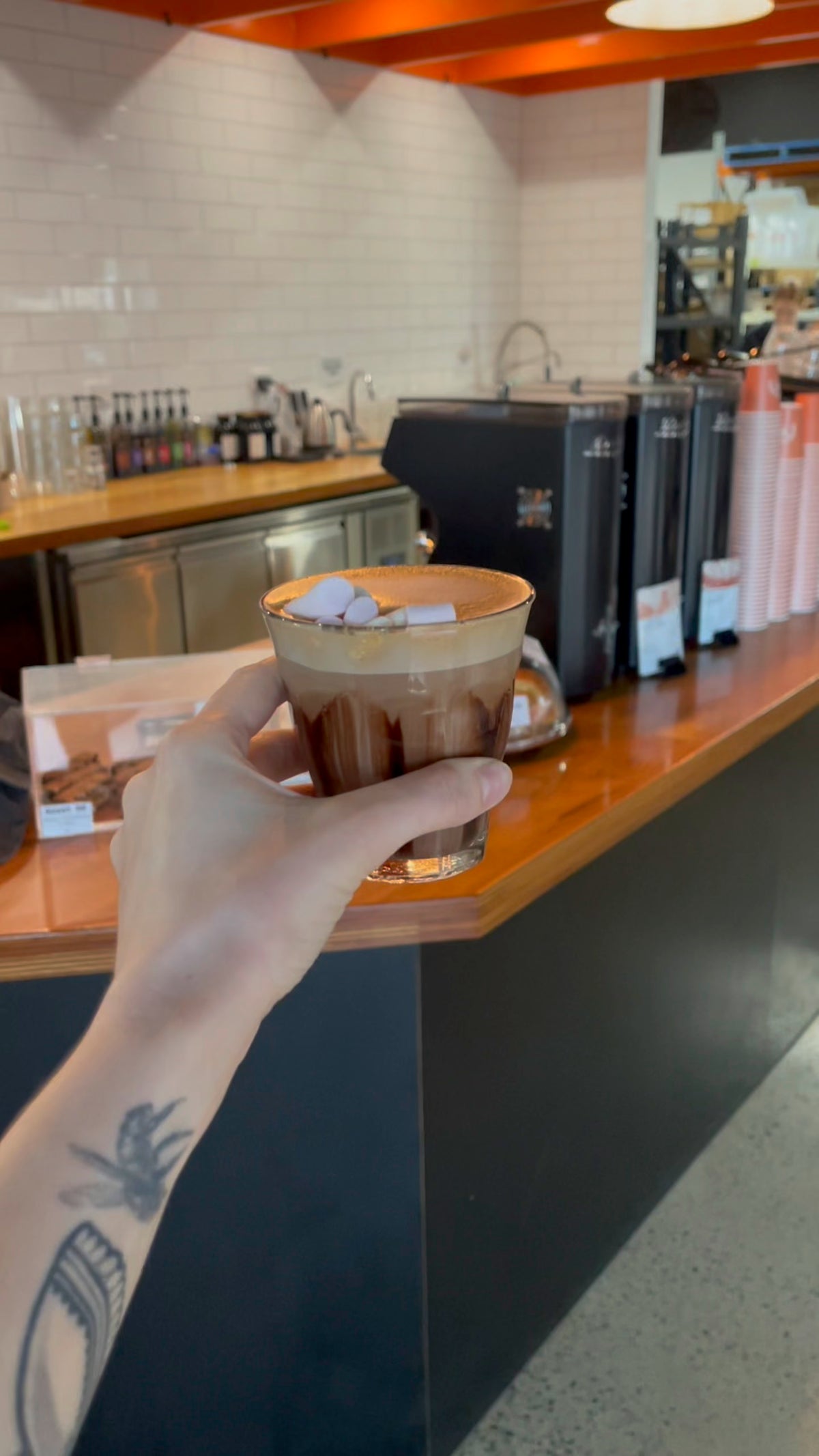 Latte in a glass held up at the River City Coffee Roasters bar