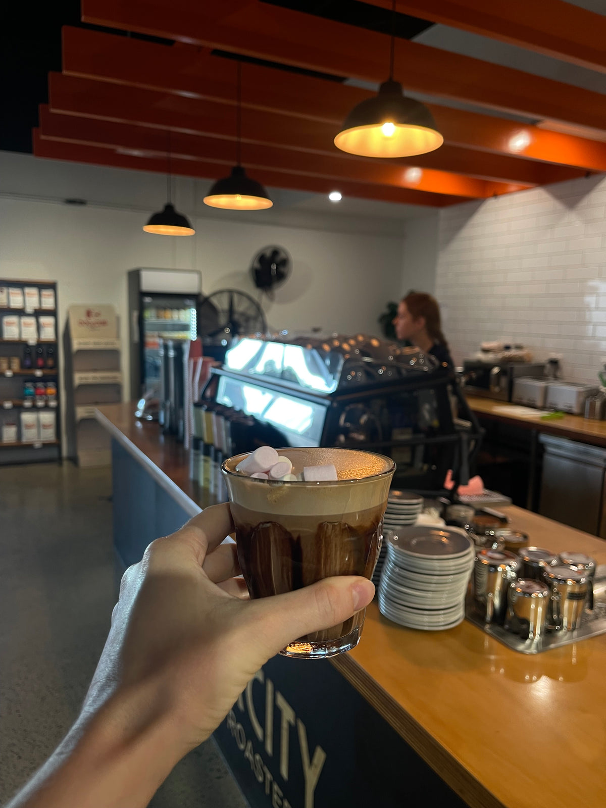 Inside the River City Coffee Roasters café in Ormiston, coffee in hand at the counter