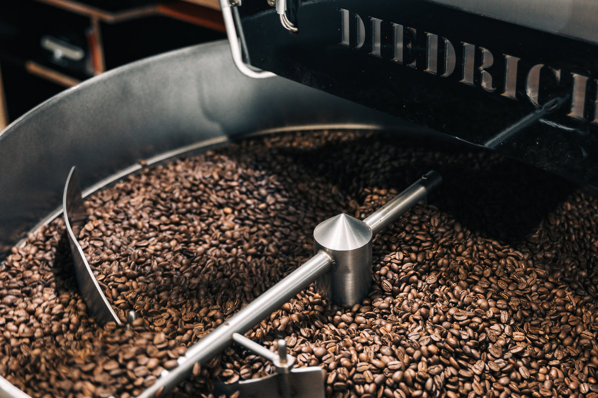 Freshly roasted coffee beans dropping from the roaster at River City Coffee Roasters